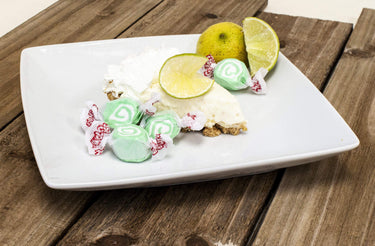 Key Lime Taffy with a slice of key lime pie and lime wedges - soft, citrus-flavored salt water taffy candy.